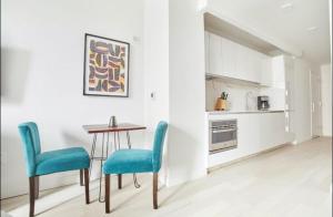 une cuisine avec une table et deux chaises bleues dans l'établissement BLACK PEARL FAMILY Apartments In CENTRUM, à Szczecin