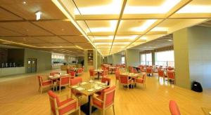 a dining room with tables and chairs in a restaurant at Jeju Booyoung Hotel in Seogwipo