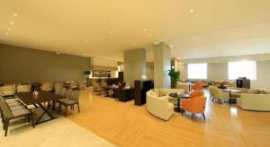 a lobby with tables and chairs in a building at Jeju Booyoung Hotel in Seogwipo