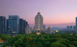 a city skyline with tall buildings and trees at dusk at Tongxiang Inspirock Hotel in Tongxiang