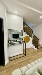 Una sala de estar con un sofá y una escalera. en Xquisite Apartment, en Lekki