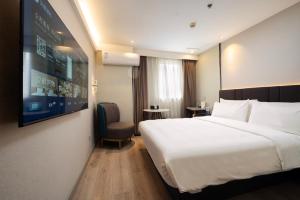 Ένα ή περισσότερα κρεβάτια σε δωμάτιο στο Hanting Hotel Shanghai Longyang Road Subway Station