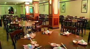 un ristorante con tavoli e sedie con le bacchette sopra di South East Asia Hotel a Singapore