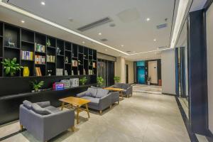 a lobby with couches and tables in a building at Xana Hotelle·Nanchang Bayi Square Metro Station in Nanchang