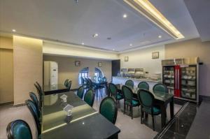 a restaurant with green chairs and tables and a counter at Xana Hotelle·Nanchang Bayi Square Metro Station in Nanchang