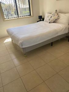 Posto letto in camera con materasso bianco di Cozy Auburn 2BR - Fast Access to Sydney & Beyond a Sydney