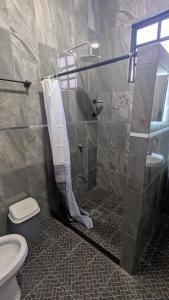 un bagno con doccia, wc e lavandino di Casa Ñogi 