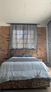 una camera da letto con un letto grande con un muro di mattoni di Casa Ñogi 