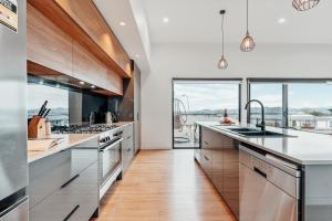 a kitchen with white counters and a large window at Luxury Family Stay-Spacious House & Granny Retreat in Sorell