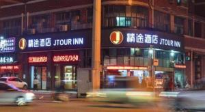 eine belebte Stadtstraße in der Nacht mit Schildern an Gebäuden in der Unterkunft JTOUR Inn Wuhan Changfeng Avenue Garden Expo in Wuhan