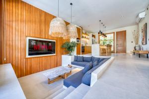 a living room with a blue couch and a table at Socis Del Boti Luxury Villas in Uluwatu +11 photos