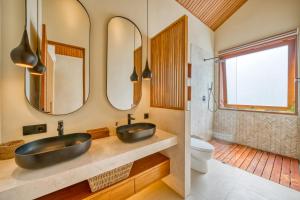 a bathroom with two sinks and two mirrors at Socis Del Boti Luxury Villas in Uluwatu