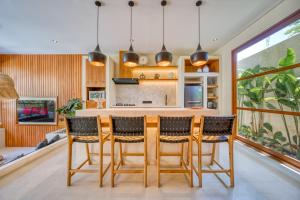 a kitchen with a wooden table and chairs at Socis Del Boti Luxury Villas in Uluwatu