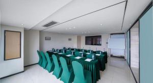 a conference room with green chairs and a white wall at City Comfort Inn Guiyang North High Speed Railway Station in Guiyang