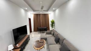 a living room with a couch and a television at Kayan 1 bhk 10 mins from everywhere in Muscat in Maţār as Sīb ad Duwalī