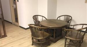 een houten tafel met vier stoelen en een houten vloer bij City Comfort Inn Zhoukou City Chuanhui District Huanghe Road in Zhoukou