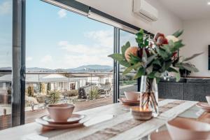 a dining room with a table with a vase of flowers at Luxury Family Stay-Spacious House & Granny Retreat in Sorell