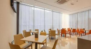 een eetkamer met tafels, stoelen en ramen bij City Comfort Inn Liuzhou Gubu Street Ma'anshan Park in Liuzhou