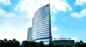 a tall building with a sign on the side of it at Ramada Plaza by Wyndham Shaowu in Liaojiapai
