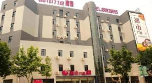 ein großes weißes Gebäude mit einem Schild darauf in der Unterkunft City 118 Hotel Qingdao Licang Pedestrian Street in Laoshan