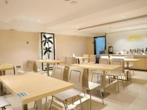 ein Restaurant mit Tischen und Stühlen und einer Küche in der Unterkunft City Comfort Inn Dongguan Shijie Jiarong Shopping Plaza in Shilong