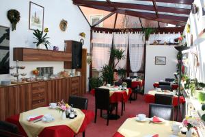 una sala da pranzo con tavoli con tovaglie rosse di Pension Am Kirschberg a Weimar