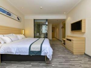 ein Hotelzimmer mit einem großen Bett und einem Fernseher in der Unterkunft City Comfort Inn Dongguan Shijie Jiarong Shopping Plaza in Shilong