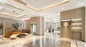 un gran vestíbulo con comedor y sala de estar en Borrman Hotel Beihai Avenue High-speed Railway Station, en Gaode