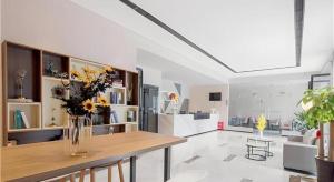 ein Wohnzimmer mit einer Vase mit Blumen auf einem Tisch in der Unterkunft Borrman Hotel Changsha Wuyi Square Yingbin Road Metro Station in Changsha