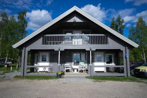 a house with a balcony and tables and chairs at Arctic Camping Finland in Pello
