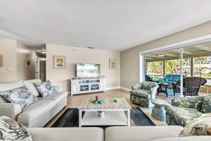 ein Wohnzimmer mit Sofa und Tisch in der Unterkunft Sand Dollar Cottage - 910 in Siesta Key