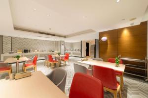 a restaurant with tables and chairs and a kitchen at Borrman Hotel Zhongshan Henglan Xiyong in Changzhou