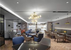 a restaurant with tables and chairs and a bar at Echarm Hotel Nanning Wuming in Wuming