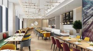 a dining room with tables and chairs in a restaurant at Green Tree Inn Express Tangshan Yueting County Bus Station in Laoting
