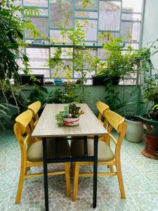 a wooden table with two chairs and a plant at Aurora Homestay - Healing Phan Thiết in Phan Thiet