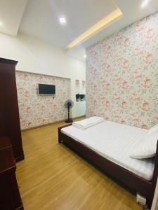 a bedroom with a bed with a floral wall at Aurora Homestay - Healing Phan Thiết in Phan Thiet