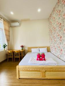two rededdy bears sitting on a bed in a bedroom at Aurora Homestay - Healing Phan Thiết in Phan Thiet