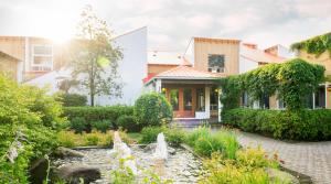 a house with a fountain in front of a garden at Hôtel Chéribourg in Magog-Orford