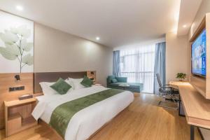 een hotelkamer met een groot bed en een tv bij GreenTree Inn Express Zhangjiagang Hexing Town Shazhou Professional Institue of Technology in Qiwei