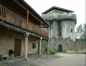 a large stone building with a large tower at Apartamento o Casa Rural Roquemar in Guijo de Granadilla