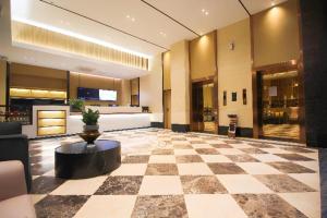 a lobby of a hotel with a checkerboard floor at City Comfort Inn Huizhou Zhongkai Huitai Industrial Park in Huizhou