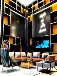 une pièce avec des chaises, une table et une télévision dans l'établissement Premier City Comfort Hotel Wuhan Yellow Crane Shouyi Road Metro Station, à Wuhan