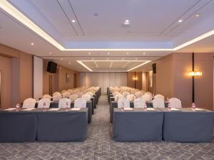 ein Konferenzraum mit Tischreihen und weißen Stühlen in der Unterkunft GreenTree Eastern Hotel Nanning Wuxiang Hangyang City in Nanning