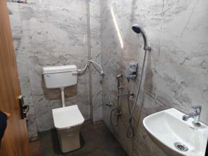 a bathroom with a shower and a toilet and a sink at Hotel O Kant in Durg
