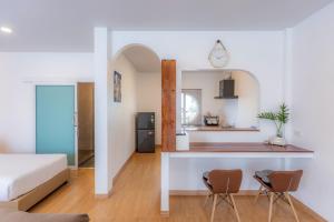 a room with a bed and two chairs and a kitchen at Sunrise Serenity Phuket Resort in Karon Beach