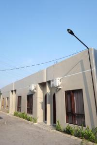 a white building with windows and a street light at Chandu at Drea Palagan Yogyakarta in Ngaglik +13 photos