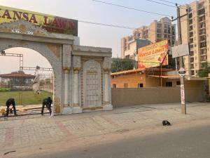 BhauliHotel O Mansa Lawn & Banquets的两名男子正在街边的一栋建筑上工作。