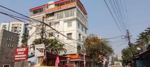 a tall white building on the side of a street at Hotel O Netaji Metro Station Kolkata Formerly Mahamaya Step Inn in Thakurpukur