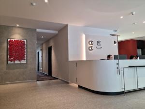 Un vestíbulo de oficina con una pintura roja en la pared. en Miico Hotel Permas Jaya, en Johor Bahru