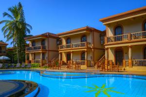 a large house with a swimming pool in front of it at Resort Terra Paraiso Goa - A Beach Property in Calangute